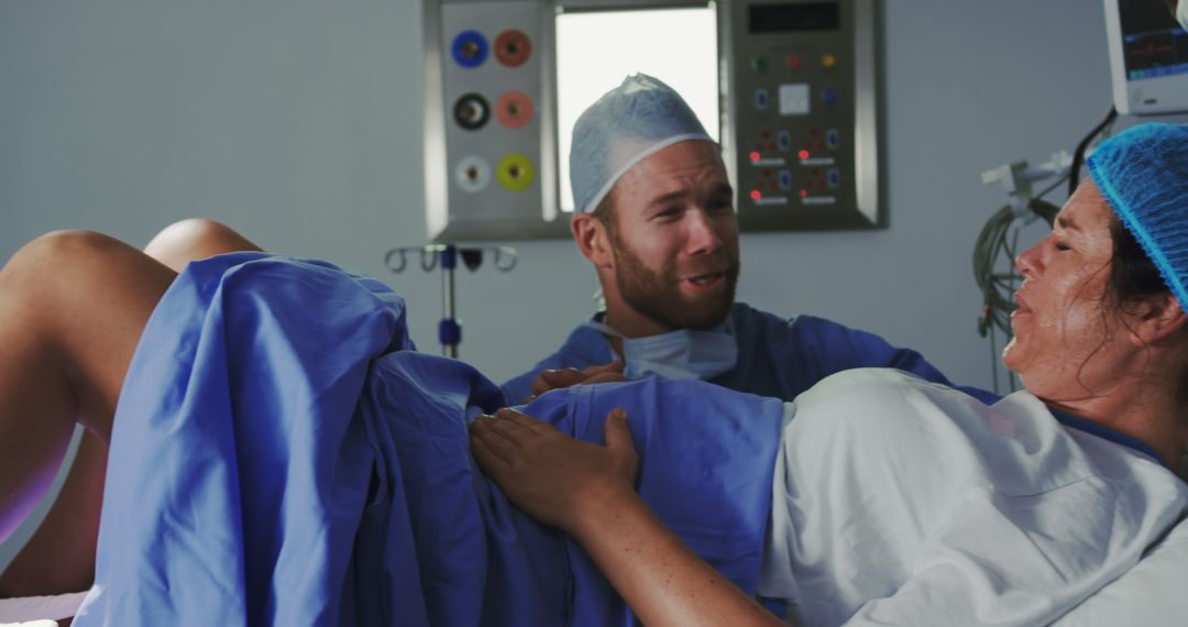 A surgeon comforts a pregnant woman in labor during a hospital operation. - Free Images, Stock Photos and Pictures on Pikwizard.com