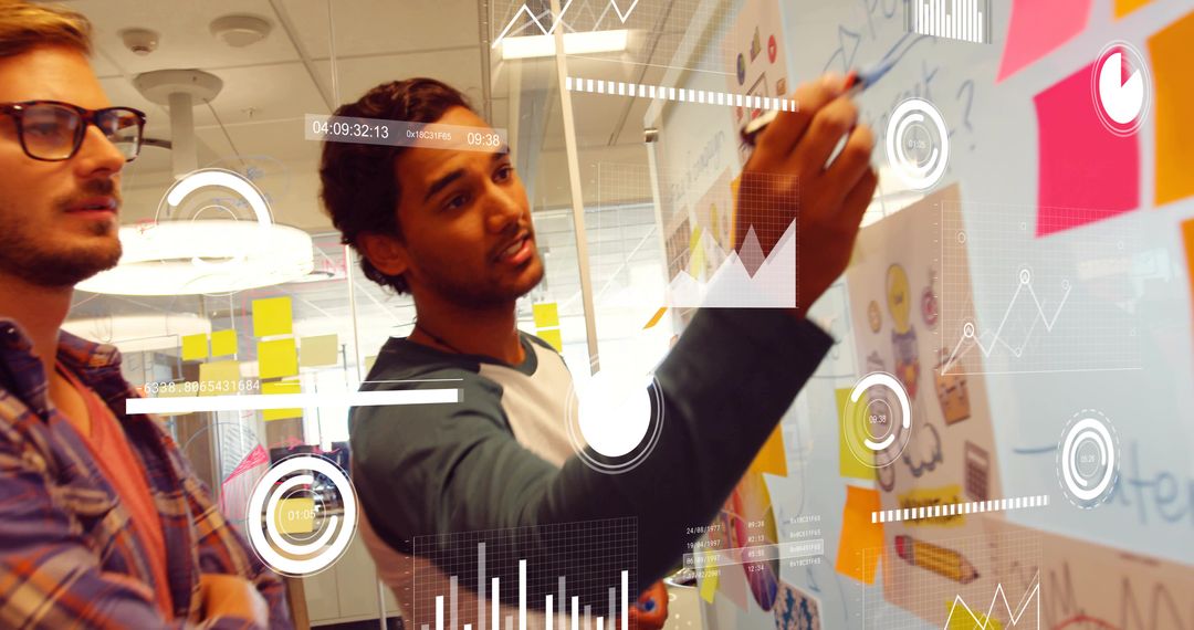 Young creative team brainstorming on glass wall with sticky notes and data overlays