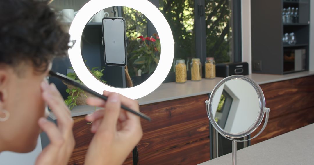 Man Applying Makeup in Kitchen with Ring Light and Mirror