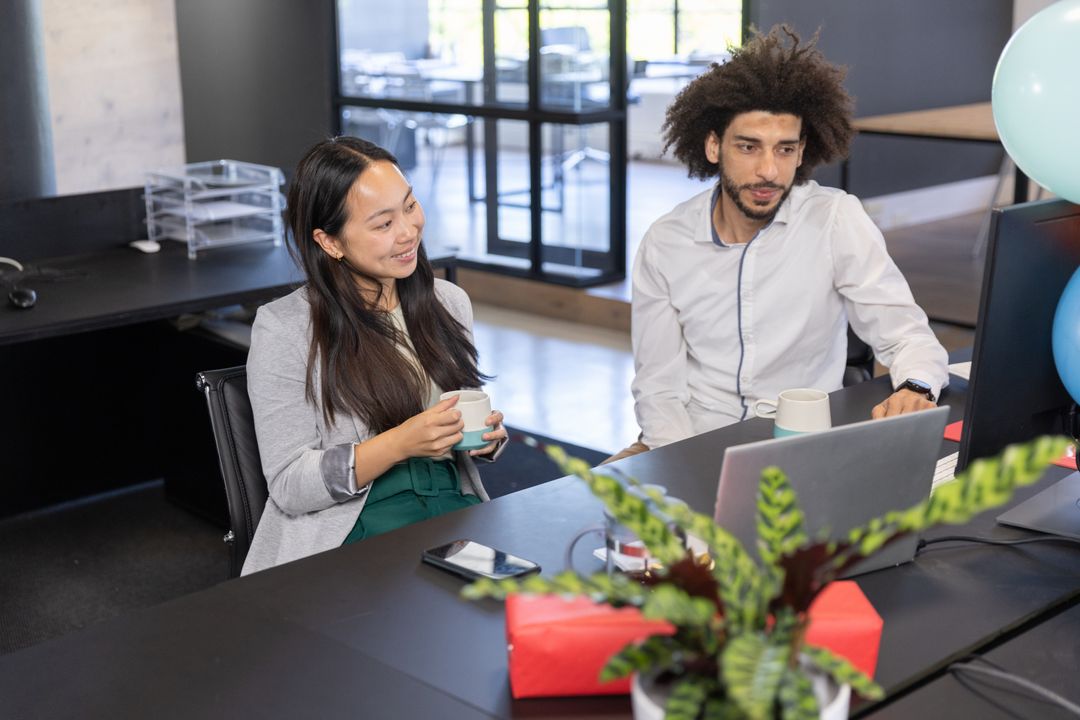 Diverse Coworkers Collaborating in Modern Workspace with Technology