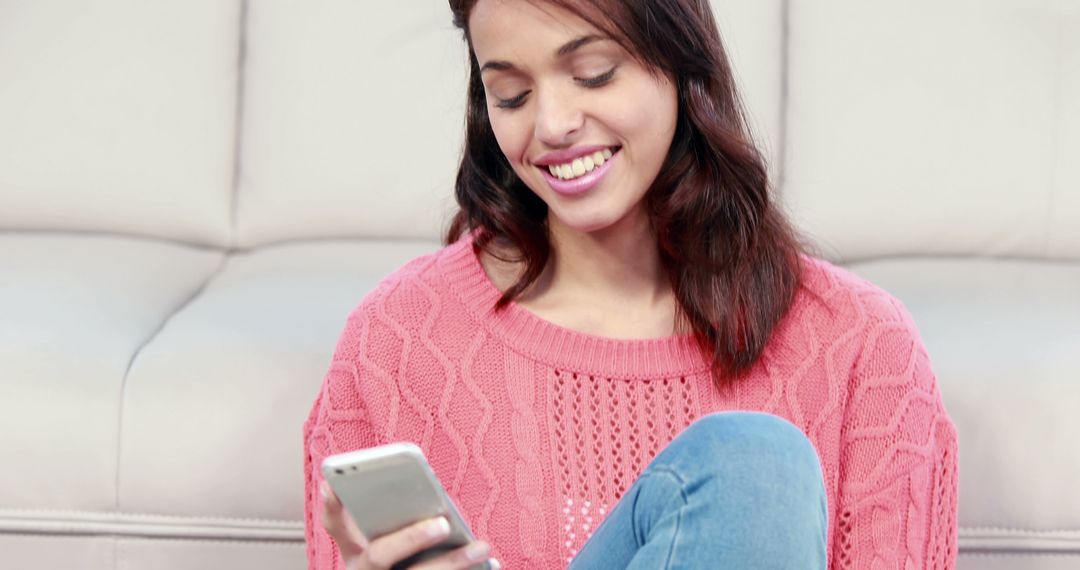 Smiling Woman Enjoying Mobile Phone on Couch - Free Images, Stock Photos and Pictures on Pikwizard.com