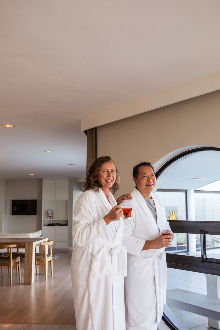Senior Couple Relaxing in Luxury Suite with Refreshing Drinks