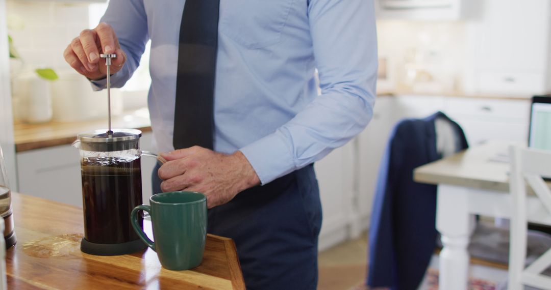 Businessman Making Coffee with French Press in Kitchen - Free Images, Stock Photos and Pictures on Pikwizard.com