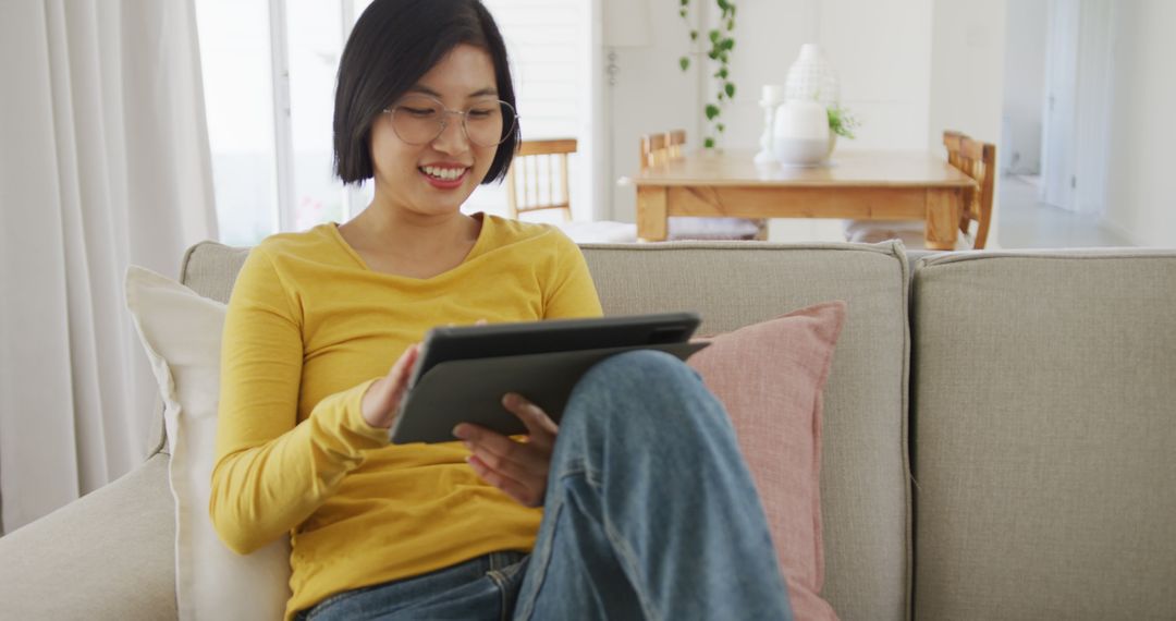 Young Woman using Digital Tablet in Modern Living Room - Free Images, Stock Photos and Pictures on Pikwizard.com