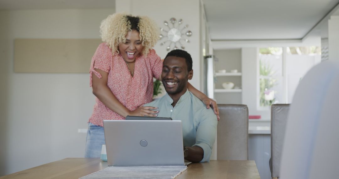Happy Couple Sharing Joyful Moment with Laptop at Home