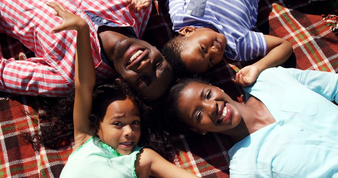 Smiling African American Family Lying on Picnic Blanket Outdoors - Free Images, Stock Photos and Pictures on Pikwizard.com