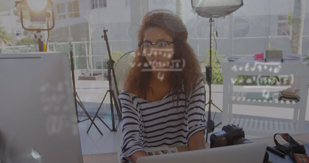 Young Creator Managing DSLR Camera with Laptop in Bright Studio