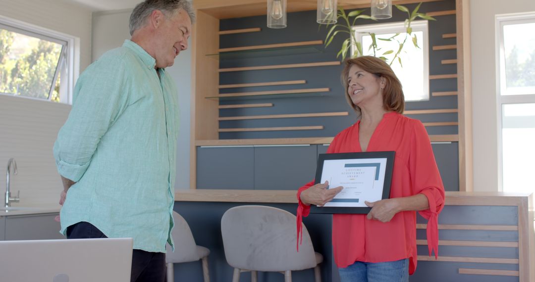 Senior Couple Celebrating Achievement with Certificate at Home