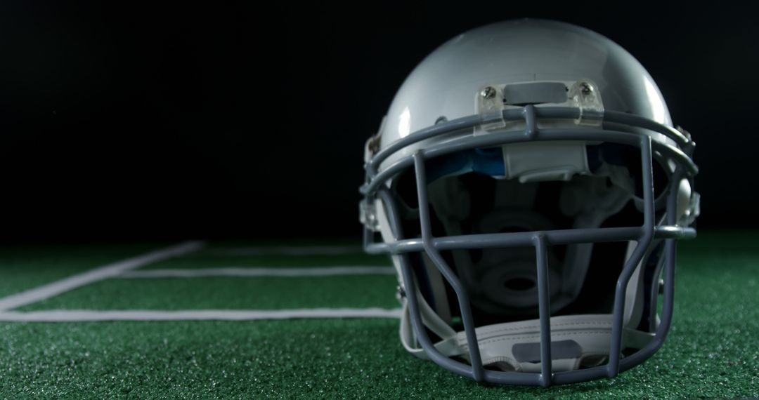 American Football Helmet on Field with Dark Background - Free Images, Stock Photos and Pictures on Pikwizard.com