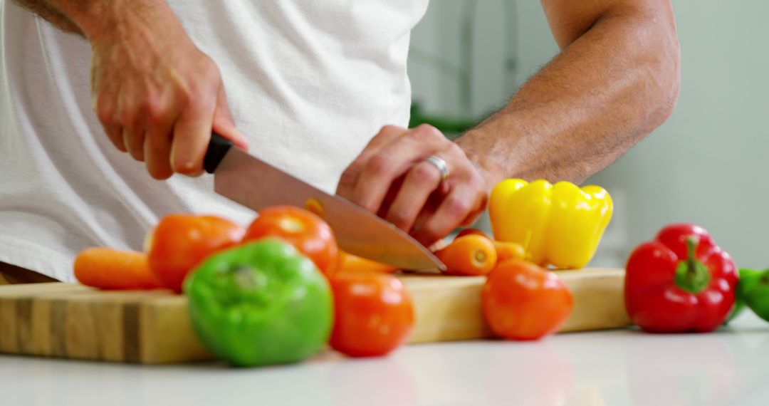 Man Chopping Vegetables on Wooden Cutting Board in Kitchen - Free Images, Stock Photos and Pictures on Pikwizard.com