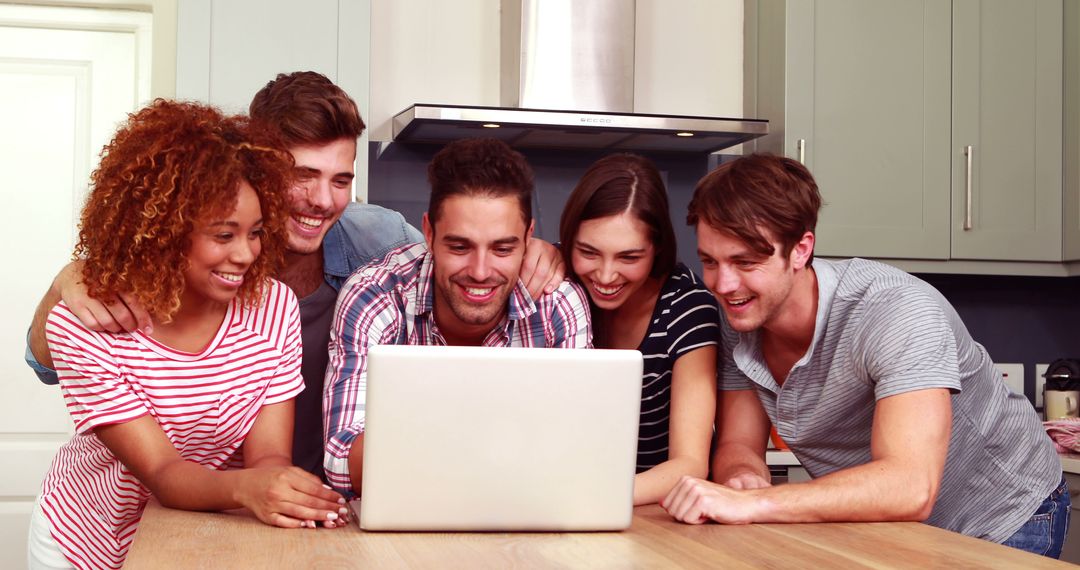 Diverse Group of Friends Laughing Together While Watching Laptop in Kitchen - Free Images, Stock Photos and Pictures on Pikwizard.com