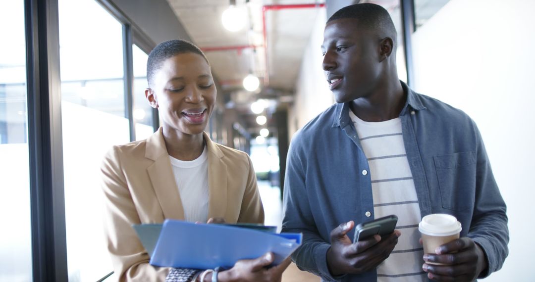 Coworkers Discussing Project While Walking Through Office