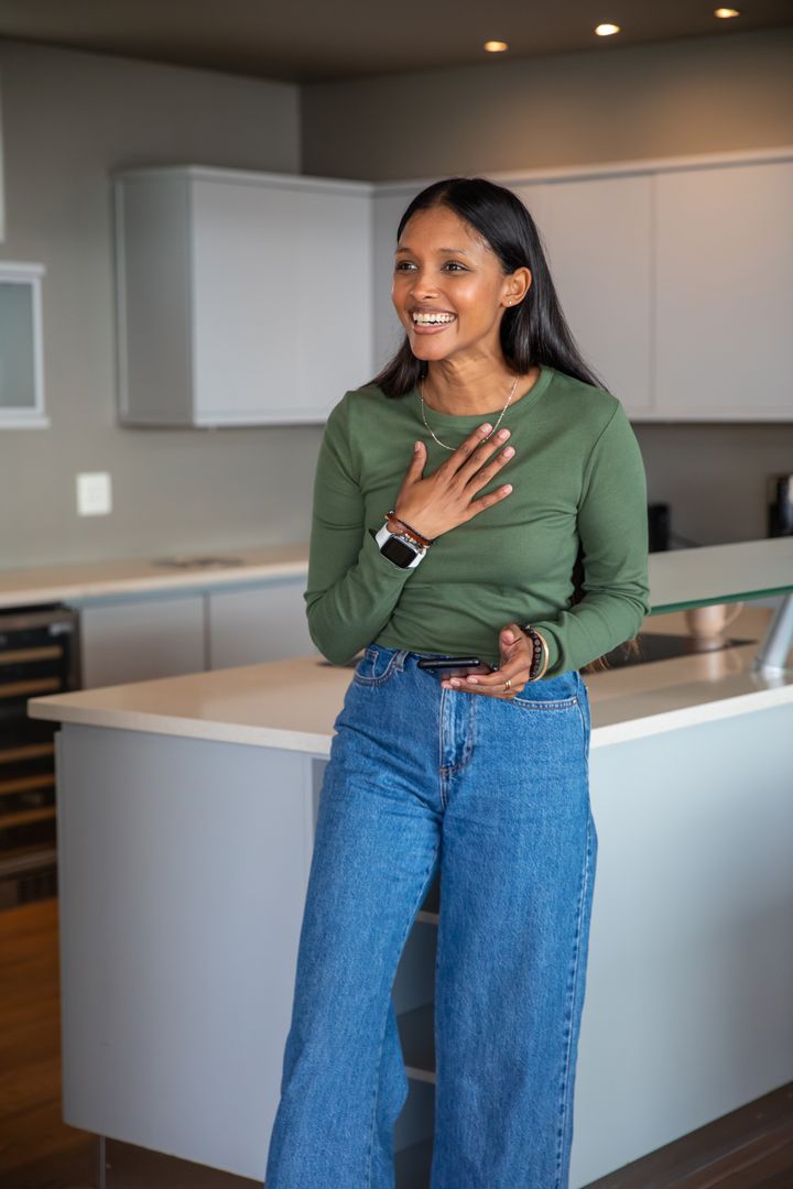 Smiling Woman Engaging with Smartwatch in Contemporary Kitchen