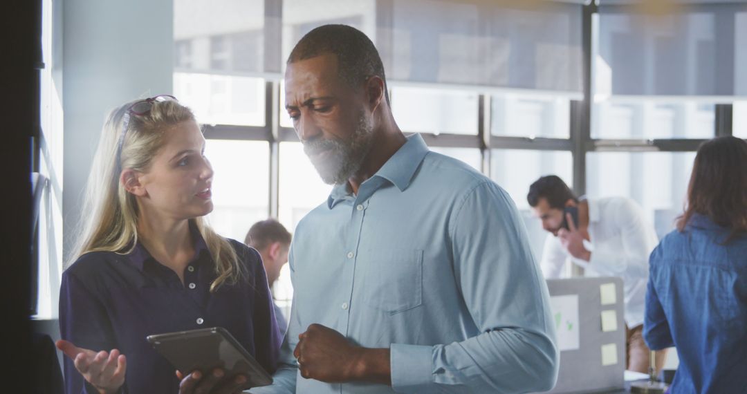 Colleagues Collaborate Using Digital Tablet in Modern Office