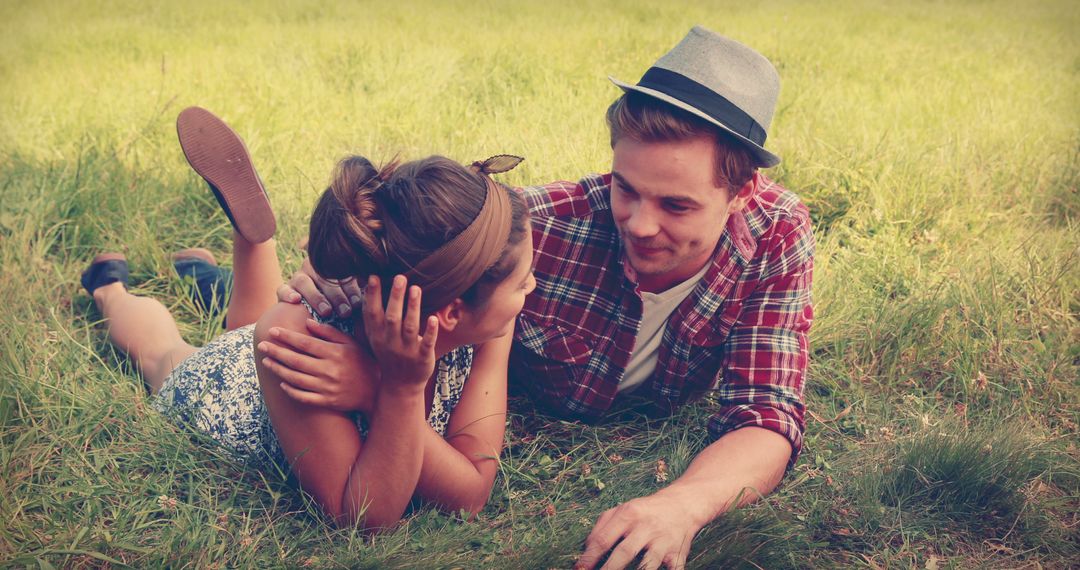 A young Caucasian couple is enjoying a romantic moment lying on the grass, with copy space - Free Images, Stock Photos and Pictures on Pikwizard.com