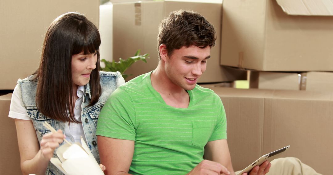 Couple Organizing New Home Among Moving Boxes