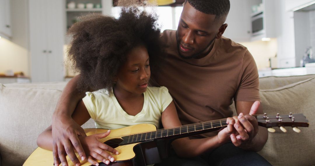 Father Teaching Daughter to Play Acoustic Guitar in Living Room - Free Images, Stock Photos and Pictures on Pikwizard.com