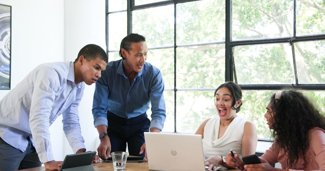 Diverse Team Joyfully Celebrating Success in Bright Office Meeting