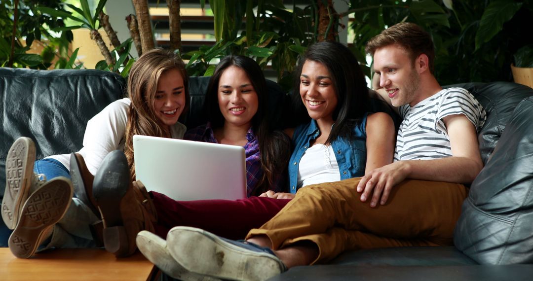 Diverse Young Adults Collaborating and Smiling at Laptop Screen