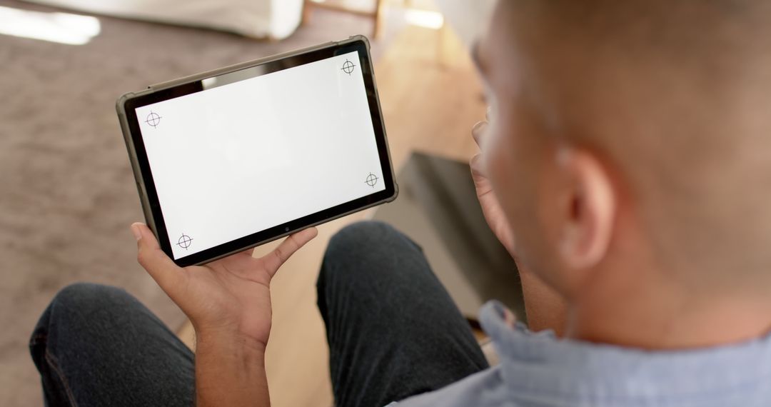 Man Using Tablet with Blank Screen in Relaxed Home Environment - Free Images, Stock Photos and Pictures on Pikwizard.com