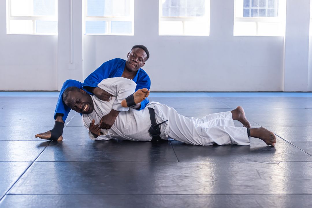 Martial Artists Practising Grappling Techniques on Dojo Mat