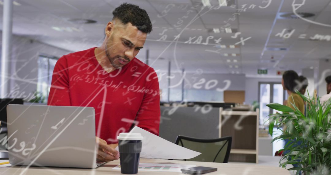 Focused Man Reviewing Charts in Modern Office Workspace