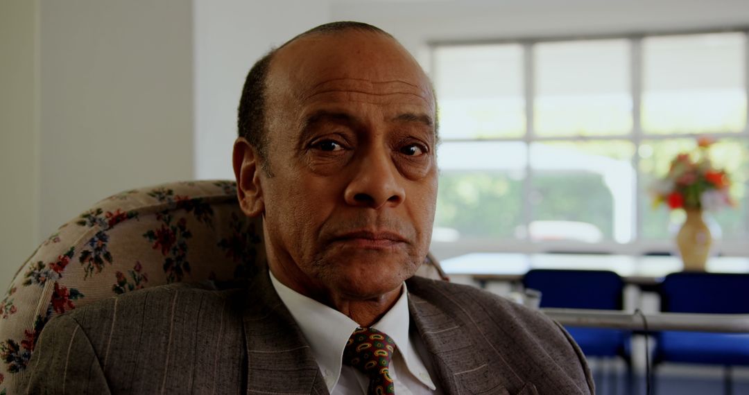 Senior Man Relaxing in Nursing Home Looking Thoughtful