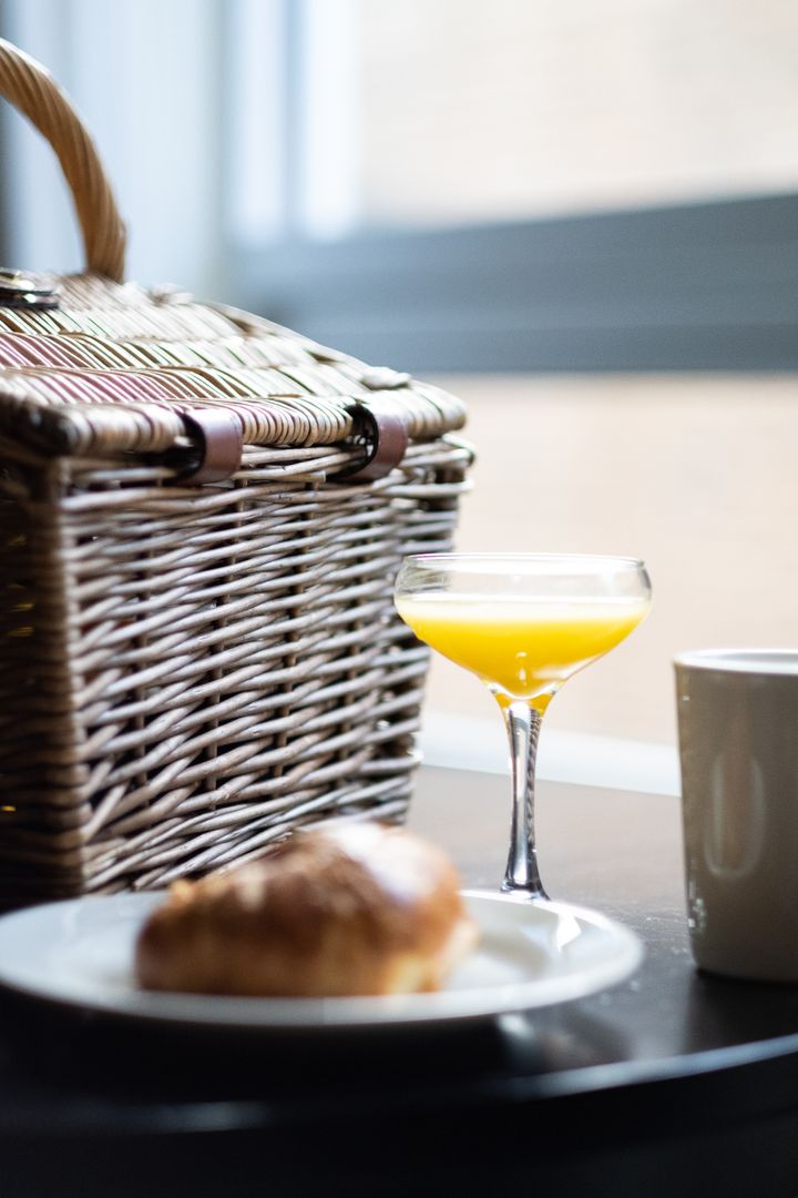 Elegant Brunch Scene with Pastry, Orange Juice, and Basket