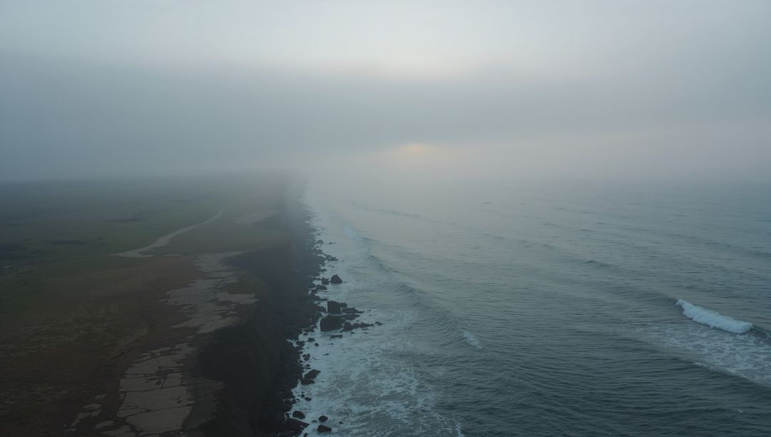 Misty Coastal Cliff Overlooking Ocean Waves at Sunrise