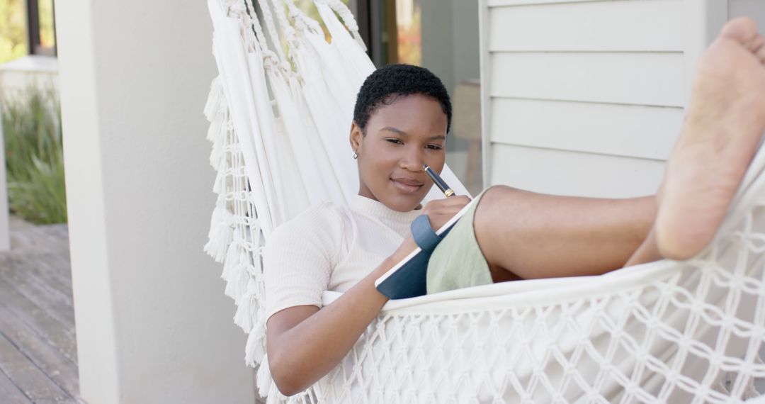 Relaxed Young Woman Writing in Notebook While Resting in Hammock Outdoors - Free Images, Stock Photos and Pictures on Pikwizard.com