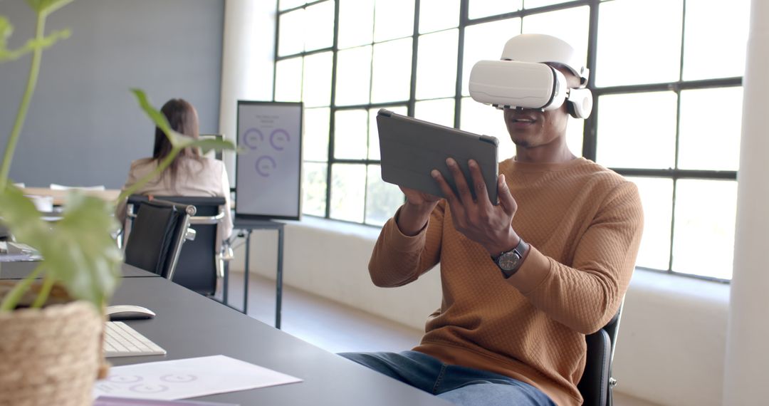 Young Professional Engaging with VR Headset and Tablet in Modern Office