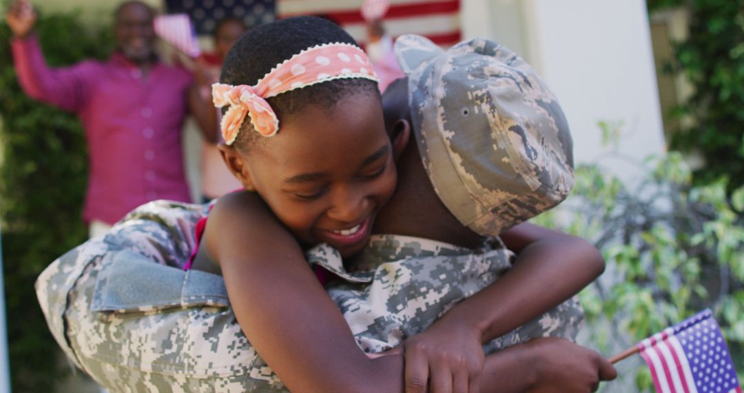 African american soldier father hugging smiling daughter with family and american flag behind - Free Images, Stock Photos and Pictures on Pikwizard.com