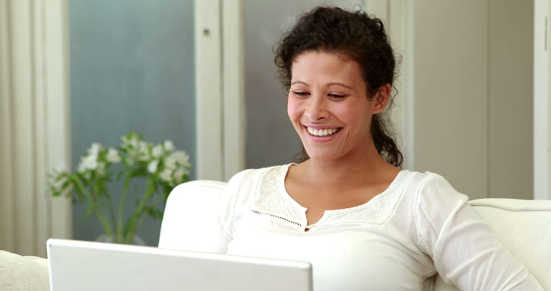 Smiling Woman Using Laptop on Couch at Home - Free Images, Stock Photos and Pictures on Pikwizard.com