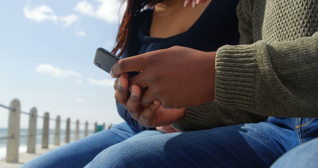 Close-Up of Couple Using Smartphone on Sunny Promenade