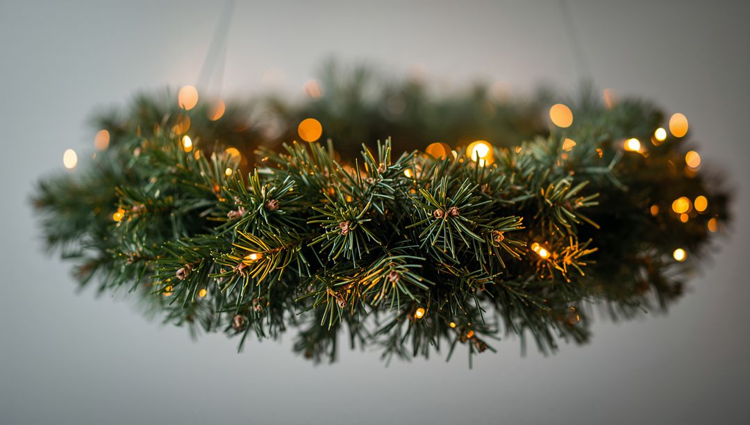Hanging Evergreen Wreath with Warm String Lights and Soft Bokeh for Holiday Decor