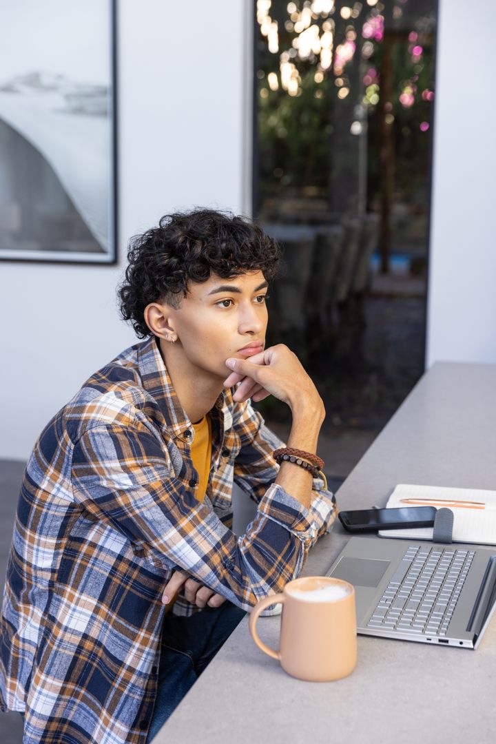 Young Man Contemplating in Modern Workspace with View