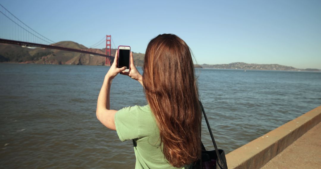 Woman Taking Photograph of Golden Gate Bridge with Smartphone - Free Images, Stock Photos and Pictures on Pikwizard.com