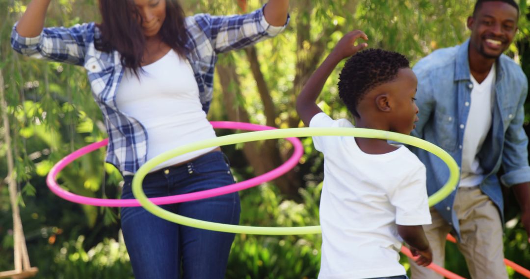 Joyful Family Hula Hooping in Garden on Sunny Day - Free Images, Stock Photos and Pictures on Pikwizard.com