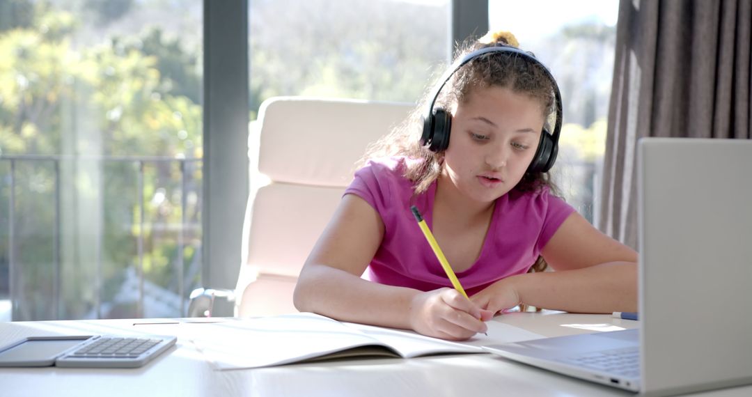 Young Girl Wearing Headphones Studying at Home with Laptop - Free Images, Stock Photos and Pictures on Pikwizard.com