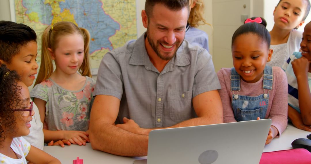 Engaged Kids Learning with Teacher Using Laptop in Classroom