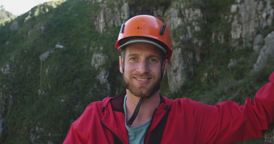 Smiling Young Man in Red Jacket with Helmet on Hiking Adventure - Free Images, Stock Photos and Pictures on Pikwizard.com