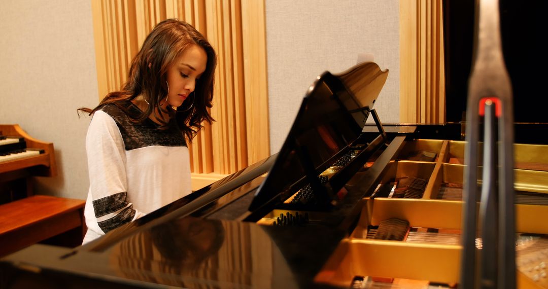 Young Woman Playing Piano in Music Studio - Free Images, Stock Photos and Pictures on Pikwizard.com