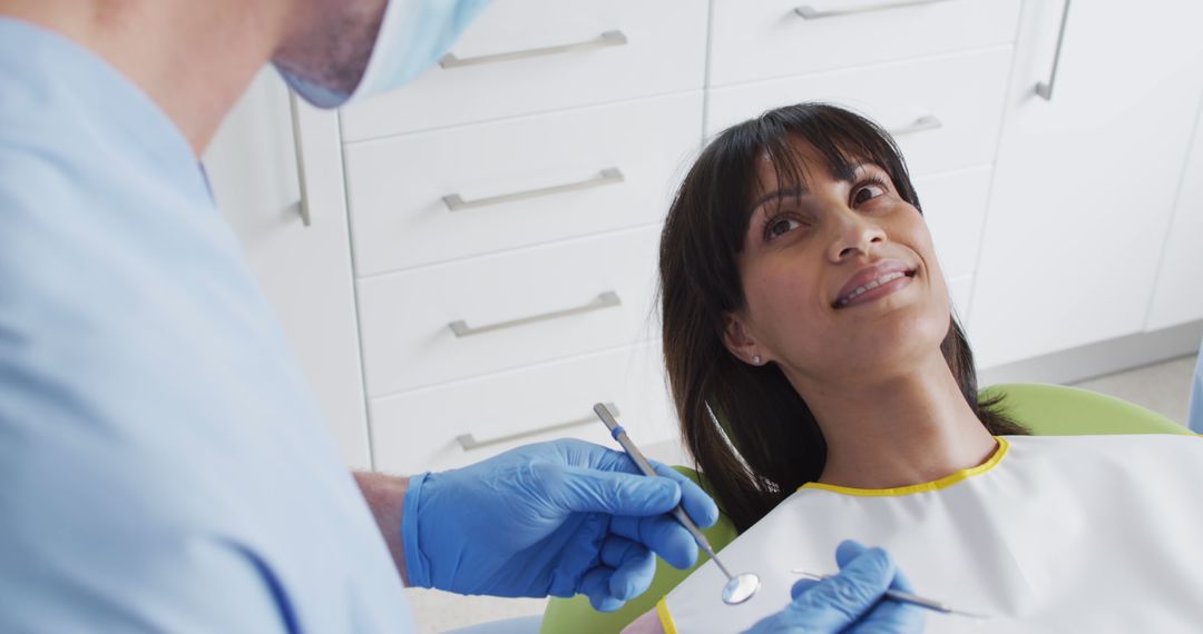 Dentist Examining Smiling Woman Patient in Dental Clinic - Free Images, Stock Photos and Pictures on Pikwizard.com