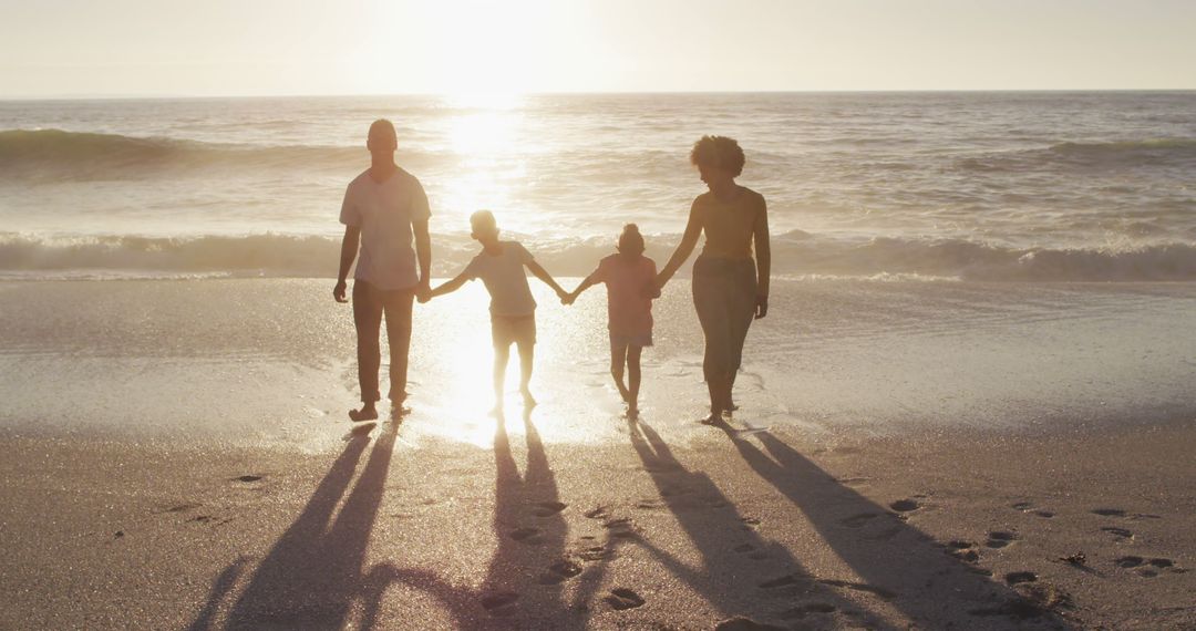 Family Holding Hands on Sunny Beach at Sunset - Free Images, Stock Photos and Pictures on Pikwizard.com