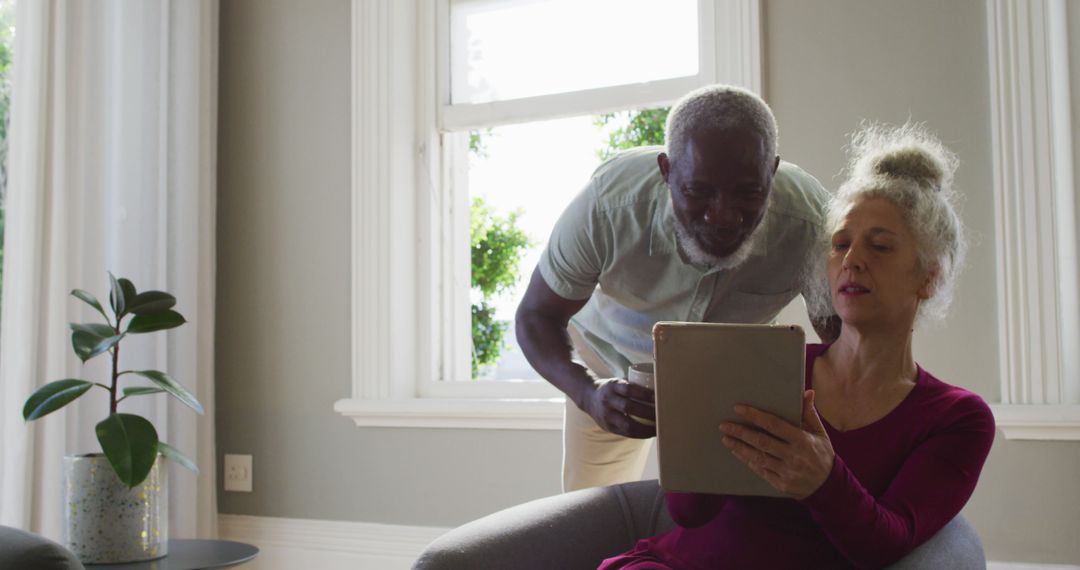 Senior Couple Enjoying Time Using Digital Tablet at Home