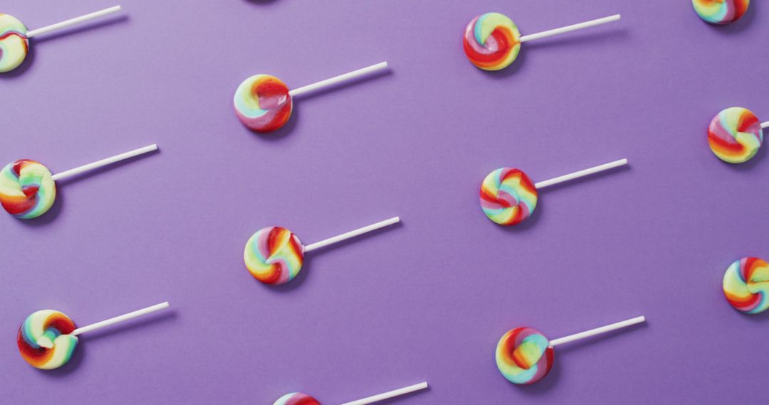 Colorful Lollipops on Purple Background in Repetitive Pattern - Free Images, Stock Photos and Pictures on Pikwizard.com