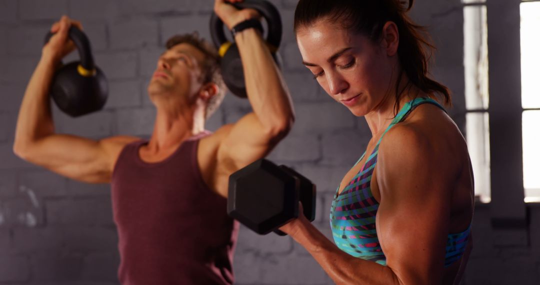 Man and Woman Focusing on Strength Training in Gym