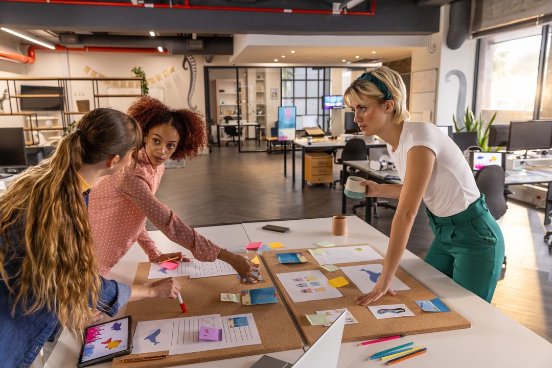 Dynamic Women Team Analyzing Charts in Modern Office Workspace