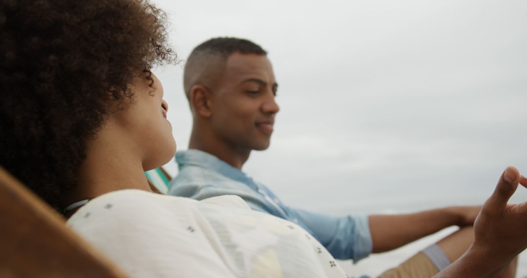 Happy Couple Relaxing on Beachside Deckchairs in Summer