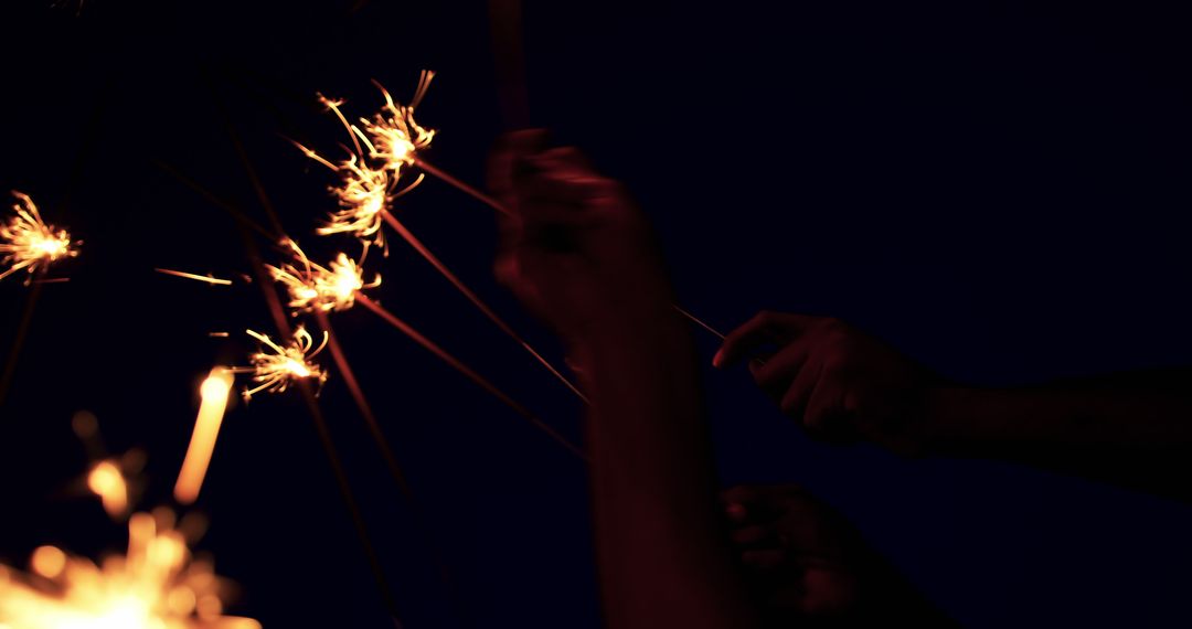 Friends Celebrating with Sparklers Against Night Sky - Free Images, Stock Photos and Pictures on Pikwizard.com